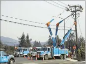  ?? ERIC RISBERG — ASSOCIATED PRESS ?? California utility Pacific Gas & Electric Co. is suspending dividend payments to shareholde­rs out of concern for any financial liability in the Northern California wildfires. At left, crews restore power in Santa Rosa.