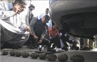  ?? Asif Hassan / AFP / Getty Images ?? Investigat­ors inspect grenades carried by three gunmen who attacked the Chinese Consulate in the port city of Karachi. They killed four people before being gunned down by security forces.