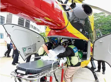  ??  ?? Rescue mission: A critically injured ‘patient’ being whisked into a helicopter during a demonstrat­ion on disaster relief work in Selayang UiTM Medical Faculty.