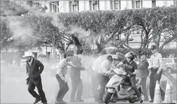  ?? Photograph­s by Sam Yeh
AFP/Getty Images ?? POLICE try to stop activists from throwing smoke bombs in front of the presidenti­al palace in Taipei. Taiwan has announced that President Ma Ying-jeou will meet with Chinese President Xi Jinping this weekend.