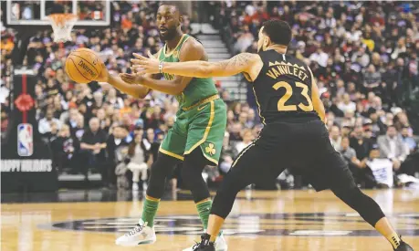  ??  ?? Celtics guard Kemba Walker moves the ball as Raptors guard Fred Vanvleet defends in Christmas Day NBA action.
DAN HAMILTON/USA TODAY SPORTS