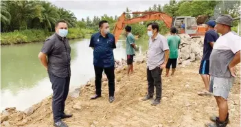  ??  ?? Wetrom (second left) visiting the project site of river bank fortress for Kampung Tambun and Kg Marudu Laut.