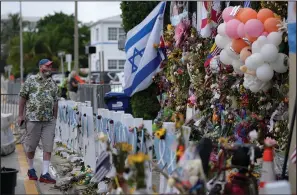  ?? (AP/Rebecca Blackwell) ?? Peter Martin of New York, who was in Miami visiting his brother, pays his respects Monday at a makeshift memorial for the victims of the Champlain Towers South building collapse in Surfside, Fla.