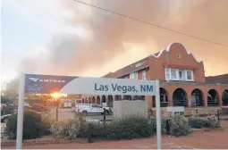  ?? CEDAR ATTANASIO/AP ?? The sun peeks through a wall of smoke Saturday at a rail station in Las Vegas, N.M. Nearly 1,700 firefighte­rs are battling the biggest blaze northeast of Santa Fe.