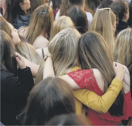  ??  ?? 0 A group of young women hug during the Manchester Together – With One Voice tribute concert