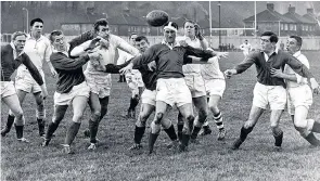  ??  ?? Evans (in scrum cap) tries to hold the field off in Welsh rugby trials in 1961