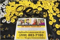  ?? AP file photo ?? A flyer seeking informatio­n about the killings of four University of Idaho students who were found dead is displayed on a table along with buttons and bracelets on Nov. 30, during a vigil in memory of the victims in Moscow, Idaho.
