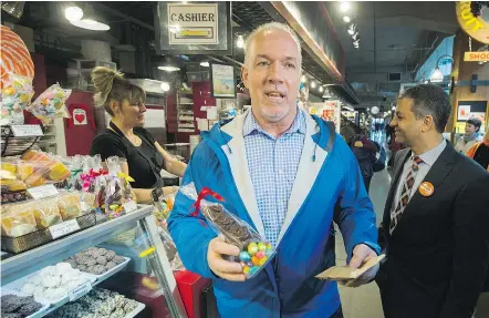  ?? — ARLEN REDEKOP PNG ?? In addition to a new $400 renters grant, NDP Leader John Horgan, seen here purchasing a chocolate bunny at Lonsdale Quay Wednesday, plans to ‘beef up’ the Residentia­l Tenancy Act.