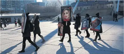  ?? R.J. JOHNSTON TORONTO STAR FILE PHOTO ?? Families at Nathan Phillips Square last year carry photos of their loved ones lost on Ukraine Internatio­nal Airlines Flight 752, which was shot down by Iran two years ago.