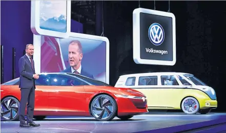  ?? [ AFP ] ?? Die Zukunft im Rampenlich­t: Herbert Diess mit Studien der geplanten Elektroaut­os von VW.