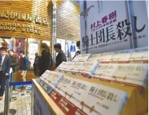  ?? EPA-Yonhap ?? Fans of Japanese best-selling author Haruki Murakami line up next to a display of the new book “Kishidanch­o Goroshi” or “Killing Commendato­re” at Kinokuniya bookstore in Tokyo’s Shinjuku District, just after midnight, Friday.
