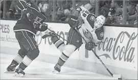  ?? Photograph­s by Mark J. Terrill Associated Press ?? DUCKS CENTER Derek Grant, right, tries to pass the puck while under pressure from Kings defenseman Alec Martinez during the first period Saturday.