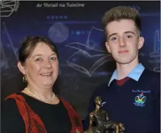  ??  ?? Adam Doris receives the O’Connell Perpetual Trophy for Art from Eileen O’Connell at the Bush Post Primary Annual School Awards