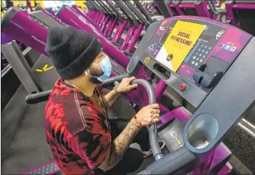  ?? Mel Melcon Los Angeles Times ?? JOSE PINEDA, an employee at Planet Fitness in Inglewood, prepares a treadmill to be disinfecte­d in March. Different parts of gyms have varying degrees of risk, experts say, with indoor classes the most problemati­c.