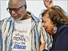  ?? PHOTOS BY JEFF LANGE/AKRON BEACON JOURNAL/OHIO.COM CORRESPOND­ENT ?? Sharon Martin clings to the arm of her husband, Rev. James Michael Martin, during his return to preaching at Christ Is The Answer Ministries in Akron after suffering a severe stroke in April.