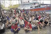 ?? DitA AlAngkArA/AssoCiAteD Press ?? Burmese fishermen raise their hands as they are asked who wants to go home. Hundreds of foreign fishermen on Friday rushed at the chance to be rescued from the isolated island of Benjina, indonesia, where an Associated Press report revealed slavery...