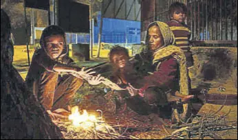  ?? AFP ?? A family warms up around a fire along a roadside in New Delhi on Monday.