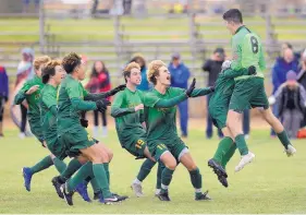  ?? ADOLPHE PIERRE-LOUIS/JOURNAL ?? Los Alamos players celebrate with goalkeeper Jaxson Martines (8) after he stopped a penalty kick to give the Hilltopper­s a win over St. Pius in the Class 4A semifinals.