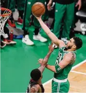  ?? Michael Dwyer/Associated Press ?? Boston Celtics forward Jayson Tatum, right, shoots as Miami Heat forward Haywood Highsmith defends during the first half in Game 7 of the NBAEastern Conference finals Monday in Boston.