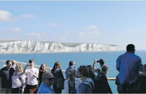  ?? — THE CANADIAN PRESS FILES ?? Travellers on a group tour view the White Cliffs of Dover from a ferry crossing from Britain to Calais, France.