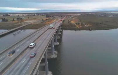  ?? Carlos Avila Gonzalez / The Chronicle ?? Traffic crosses the Napa River on Highway 37, which is at risk of sea level rise. While many threats posed by climate change involve short sections of roadway, nearly all 9 miles of Highway 37 in Sonoma County are vulnerable.