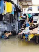 ?? AP ?? Afectados buscaban agua potable en medio de las inundacion­es en el norte de la capital, Manila.