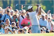  ?? MATT SLOCUM/ASSOCIATED PRESS ?? Tiger Woods watches his tee shot on the 12th hole during Tuesday’s practice round at Augusta National with Phil Mickelson. The Masters opens Thursday.