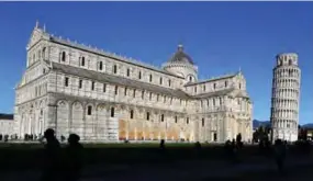  ??  ?? A tourist takes pictures of the Pisa Tower (right) and the Pisa Cathedral, a medieval Roman Catholic cathedral dedicated to the Assumption of the Virgin Mary in Pisa. — AFP photos