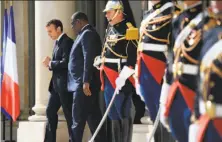  ?? Lionel Bonaventur­e / AFP / Getty Images ?? French President Emmanuel Macron (left) escorts his Senegalese counterpar­t Macky Sall after meeting in Paris.