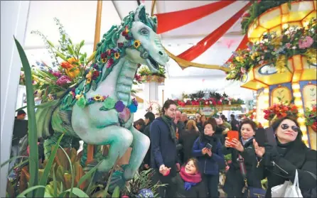  ?? XINHUA ?? A horse sculpture decorated with flowers draws visitors’ attention at Macy’s in New York. The floral carnival, with setups of various park scenes, opened on Sunday.