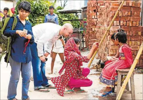  ?? Fotos: Rainbow Collective ?? Richard York, cofundador de Rainbow Collective, enseña a hijas de trabajdora­s textiles de Bangladés a rodar su propia pelìcula