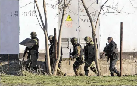  ?? Bild: SN/AP ?? Soldaten vor jener ukrainisch­en Militärbas­is in der Krim-Hauptstadt Simferopol, wo Dienstag die ersten Schüsse fielen und zwei Männer getötet wurden: Ein ukrainisch­er und ein prorussisc­her Soldat.