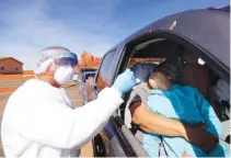  ?? KRISTIN MURPHY/THE DESERET NEWS VIA AP ?? Vehicles line up for COVID-19 testing outside of the Monument Valley Health Center in Oljato-Monument Valley, San Juan County, in April.