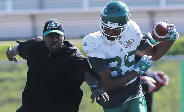  ?? MICHELLE BERG ?? Receivers coach Travis Moore helps Duron Carter with a drill during the Riders’ training camp in Saskatoon, where Carter is learning both the team’s offence and defence.