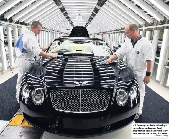  ?? Christophe­r Furlong ?? A Bentley car sits inside a light tunnel and undergoes final preparatio­n and inspection at the Bentley Motors Factory in Crewe