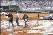  ?? WADE PAYNE - THE ASSOCIATED PRESS ?? Safety workers spread drying agent before heat races for a NASCAR Truck Series race on Saturday, March 27, 2021, in Bristol, Tenn.