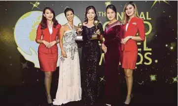  ??  ?? LAO (tengah) mewakili AirAsia bersama dua anugerah yang dimenangi di Hong Kong, baru-baru ini.