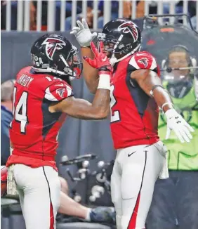  ?? THE ASSOCIATED PRESS ?? Atlanta Falcons wide receiver Justin Hardy (14) celebrates his touchdown with teammate Mohamed Sanu during the second half against the Dallas Cowboys on Sunday.