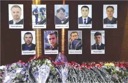  ??  ?? MOSCOW: Floral tributes in front of portraits of Russian TV journalist­s who were aboard the crashes military plane, displayed in Moscow yesterday. —AP