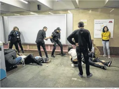  ?? ESTEBAN BIBA / EFE ?? Ciudadanos ucranianos atienden a dos heridos tras el ataque de misiles en el metro, ayer en Jarkov.