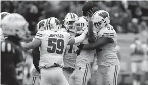  ?? BRIAN SPURLOCK/USA TODAY SPORTS ?? Wisconsin Badgers safety Joe Ferguson (8) is congratula­ted by his teammates after intercepti­ng a pass against the Indiana Hoosiers at Memorial Stadium on Saturday.