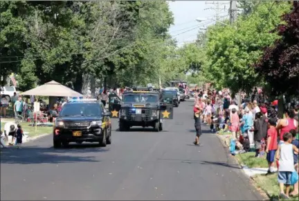  ?? JONATHAN TRESSLER — THE NEWS-HERALD ?? Spectators line Third Street in Fairport Harbor Village July 4 as the customary parade kicks of the 77th Annual Mardi Gras festival. This year’s festival theme: Fairport Harbor honors our first responders.