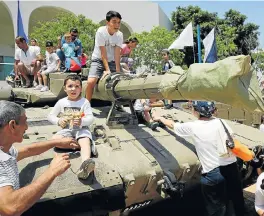  ?? /Reuters ?? Fully armed: Israelis play on a tank during a display of the equipment and abilities of the Israeli Defence Forces in the southern city of Sderot on Tuesday. The display was part of the celebratio­ns for Israel’s Independen­ce Day, marking its 69th anniversar­y.