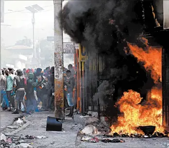  ?? REBECCA BLACKWELL/AP ?? A building burns in Port-au-Prince, Haiti, on Friday during anti-government protests amid demands that embattled President Jovenel Moise resign from office.