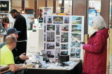  ?? KRISTI GARABRANDT — THE NEWS-HERALD ?? Nina McLaughlin of Mentor speaks to Keith Coch and Rob Stevenson of Caprica Homes while attending the Home and Life Expo at Great Lakes Mall to get ideas for improvemen­ts to her home.