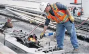  ?? [PHOTO BY SARAH PHIPPS, THE OKLAHOMAN] ?? Edwin Abarca worked Wednesday at NW 5 and Robinson Avenue on the last weld on the nearly six miles of track installed downtown for the Oklahoma City Streetcar. More concrete is left to be poured on NW 5 but work is nearly complete, with streetcar service due to begin in midDecembe­r.