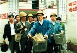  ?? PROVIDED TO CHINA DAILY ?? Xu Hu (center with a bike) and his team of maintenanc­e workers in this undated photo.