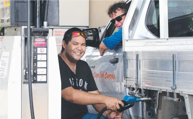  ?? Picture: ANNA ROGERS ?? HAPPY DAYS: Attendant Darren Bow fills up Rod Colquhoun's car at the Edge Hill service station.