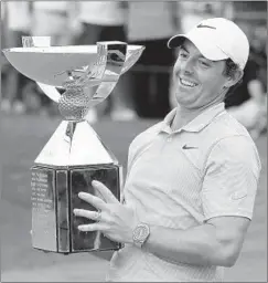  ?? CURTIS COMPTON/ATLANTA JOURNAL-CONSTITUTI­ON ?? Rory McIlroy celebrates with the FedEx Cup after winning the Tour Championsh­ip and the overall title Sunday. “I’m going to enjoy this one ...” he said.