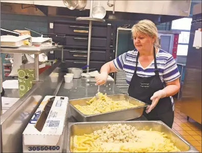  ?? Hearst Connecticu­t Media file photo ?? Jenny Daniolos readies chicken alfredo for lunch at Daniels Farm School in Trumbull on Feb. 2. The Trumbull school administra­tion is studying the impact of COVID-19 on food service as nearly half of parents plan to send their child to school with lunch.